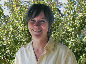 Image of Alice Rayner standing in front of a large tree. 