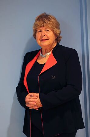 Marjorie Perloff standing in a black suit